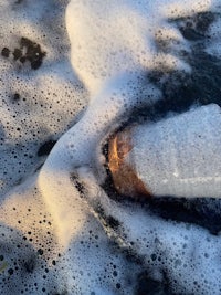 a plastic bottle in the water with foam on it